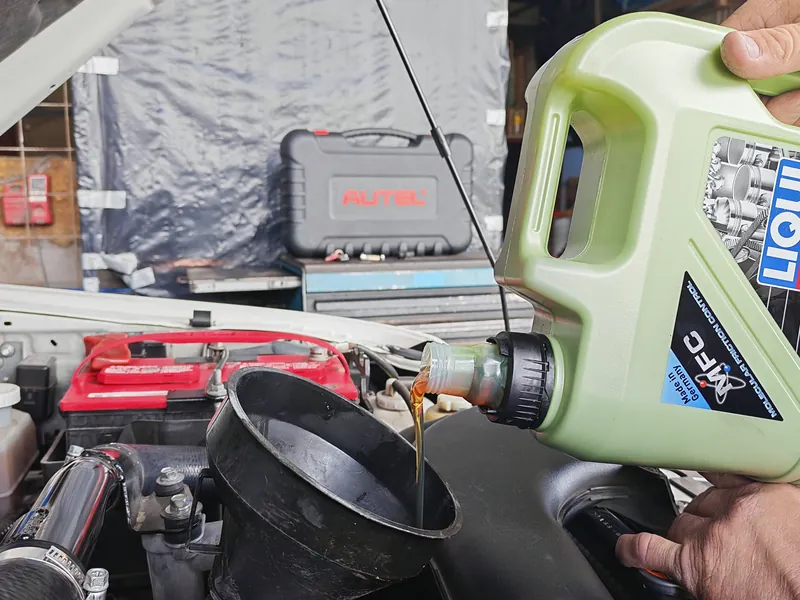 Aceite de motor siendo vertido en el vehículo